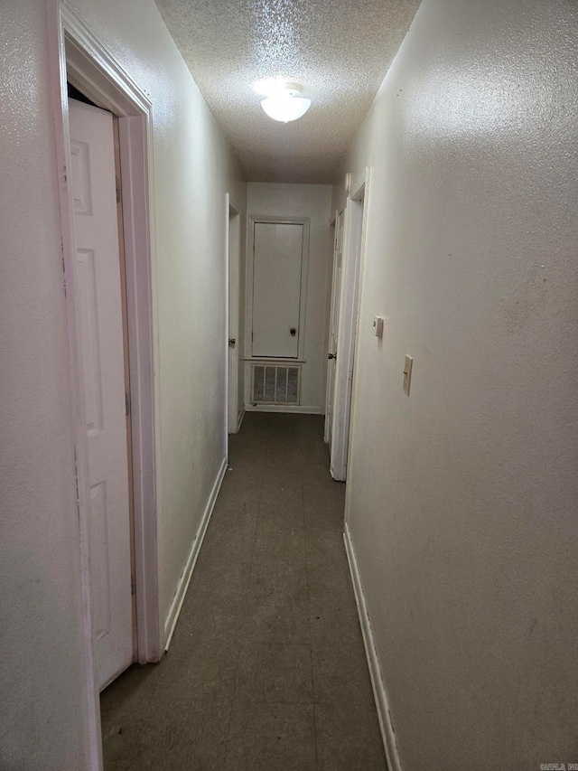 corridor featuring a textured ceiling