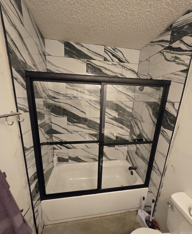 bathroom with shower / bath combination with glass door, a textured ceiling, and toilet