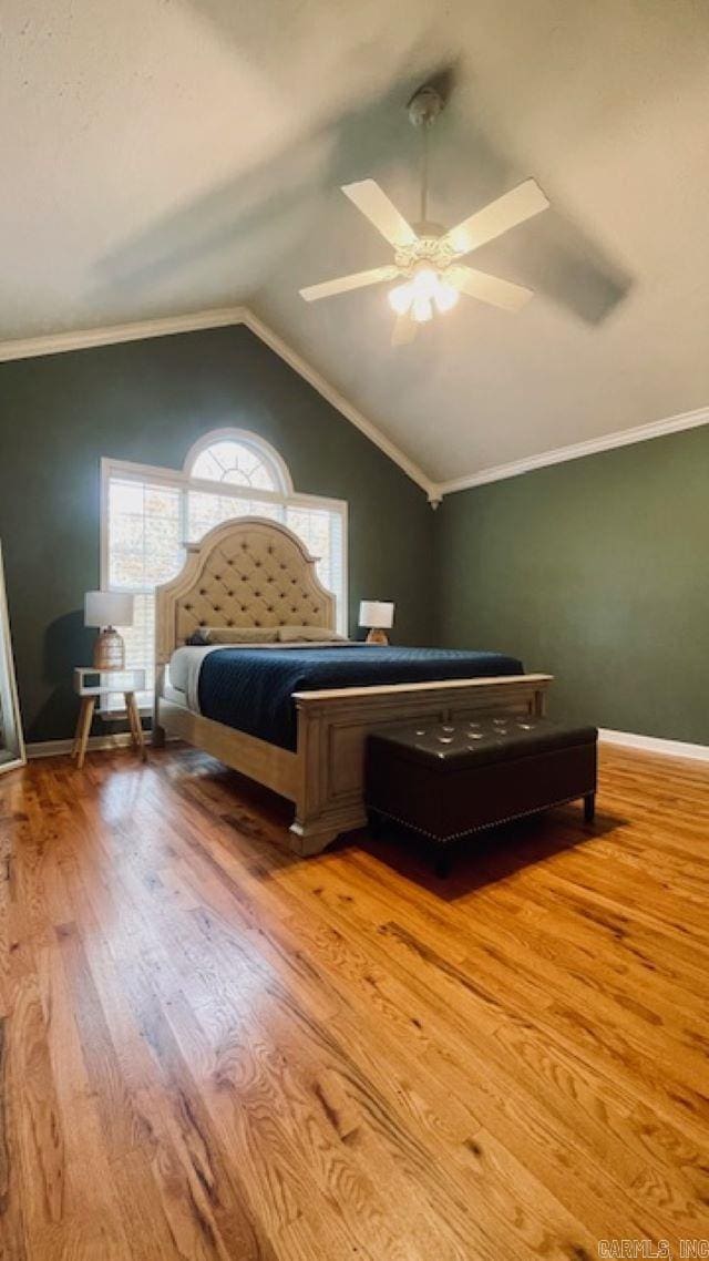 bedroom with ceiling fan, light hardwood / wood-style floors, lofted ceiling, and ornamental molding