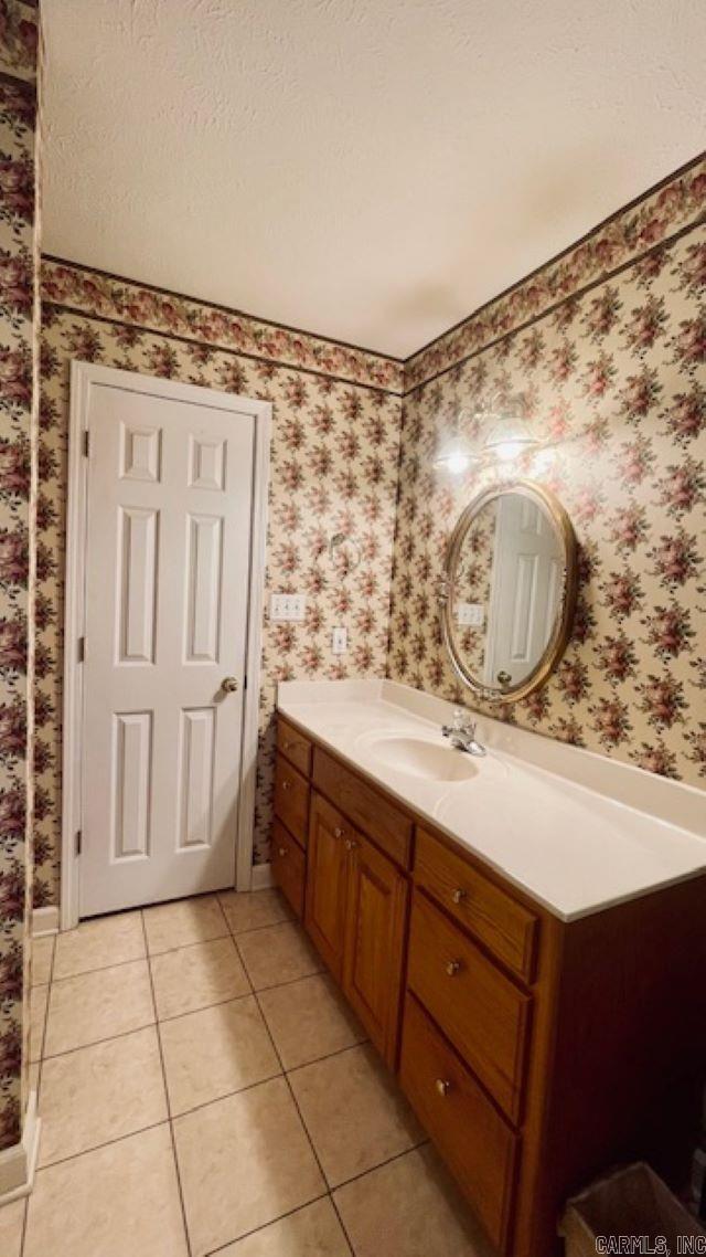 bathroom with tile patterned flooring, vanity, and a textured ceiling