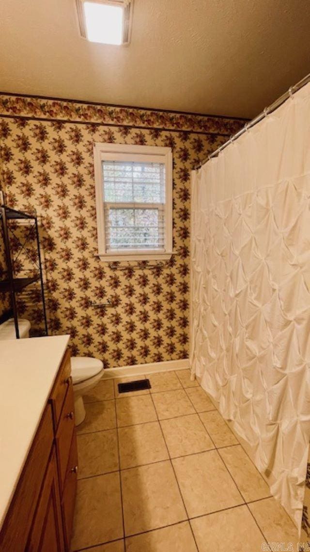 bathroom featuring tile patterned flooring, vanity, and toilet