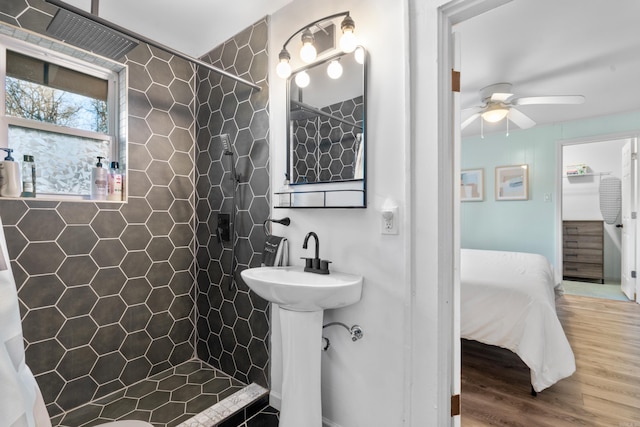 bathroom featuring a tile shower, hardwood / wood-style flooring, and ceiling fan