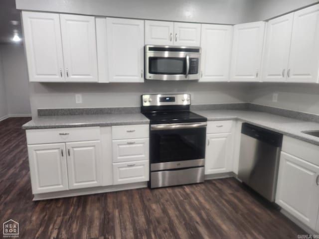 kitchen with white cabinetry, dark hardwood / wood-style floors, and appliances with stainless steel finishes