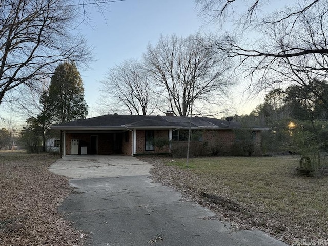 ranch-style home featuring a carport and a yard