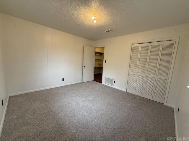 unfurnished bedroom featuring carpet flooring, a textured ceiling, and a closet