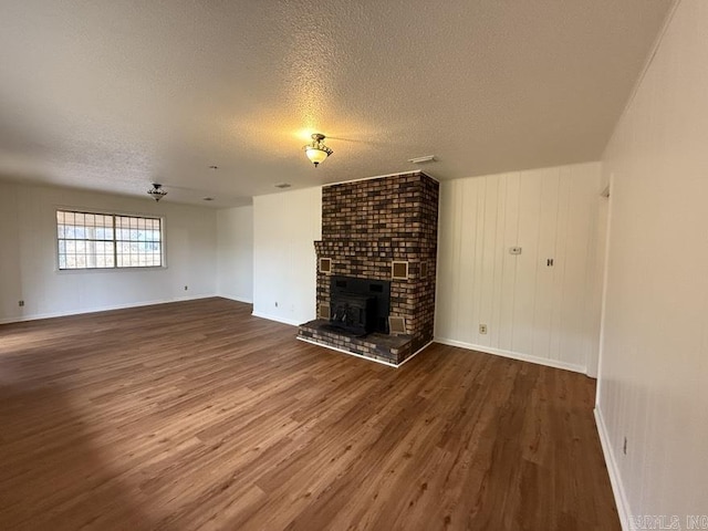 unfurnished living room with wood-type flooring and a textured ceiling