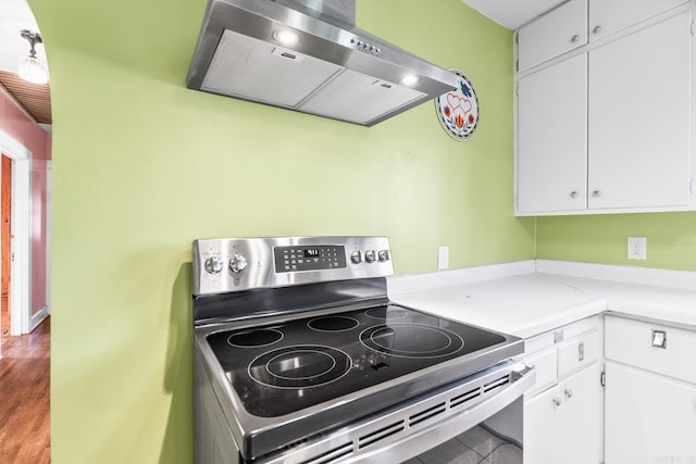 kitchen featuring electric stove, white cabinets, and ventilation hood