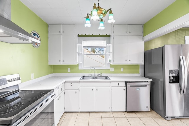 kitchen featuring wall chimney exhaust hood, stainless steel appliances, sink, white cabinetry, and hanging light fixtures