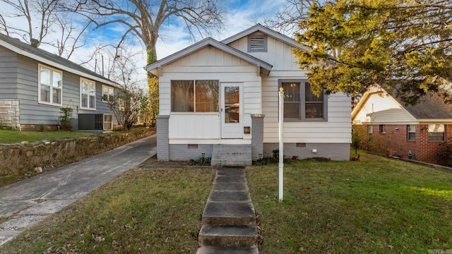 bungalow-style home with a front lawn