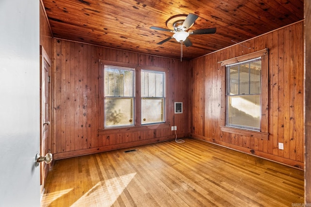 unfurnished room featuring ceiling fan, wood walls, wood ceiling, and light hardwood / wood-style flooring