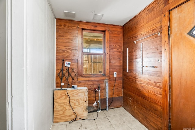 interior space with wood walls and light tile patterned floors