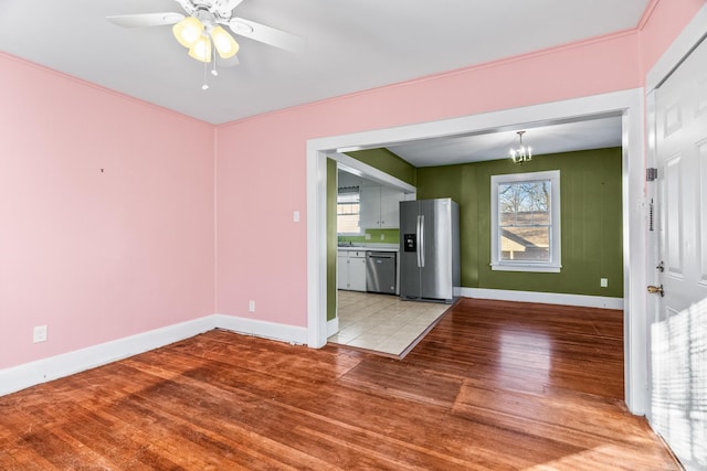 interior space with wood-type flooring and ceiling fan with notable chandelier