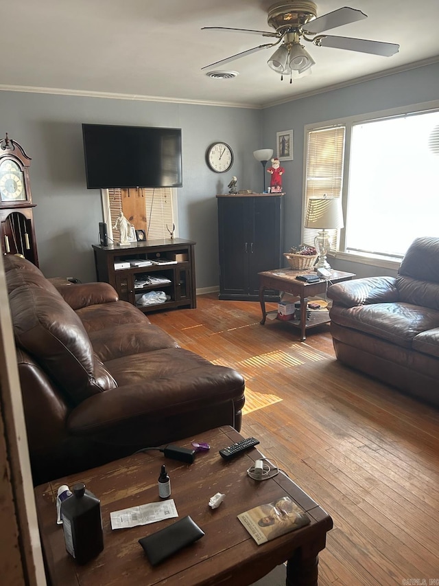 living room featuring hardwood / wood-style flooring, ceiling fan, and crown molding