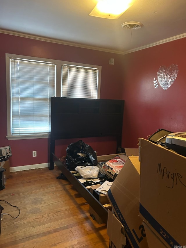 bedroom with wood-type flooring and ornamental molding