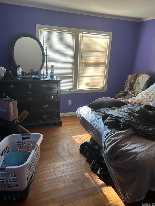 bedroom featuring wood-type flooring and crown molding