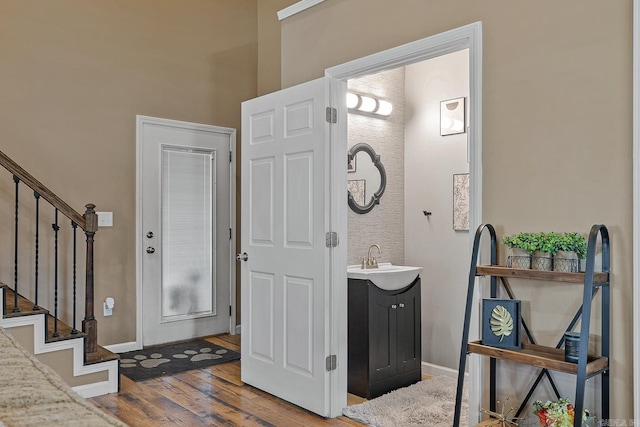 foyer featuring stairway, wood finished floors, and baseboards