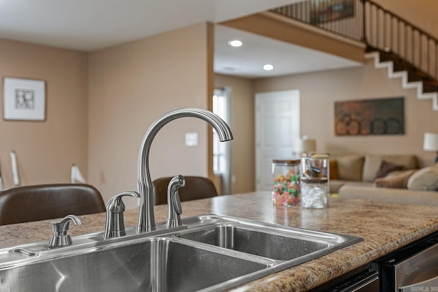 kitchen with dishwasher, open floor plan, a sink, and recessed lighting