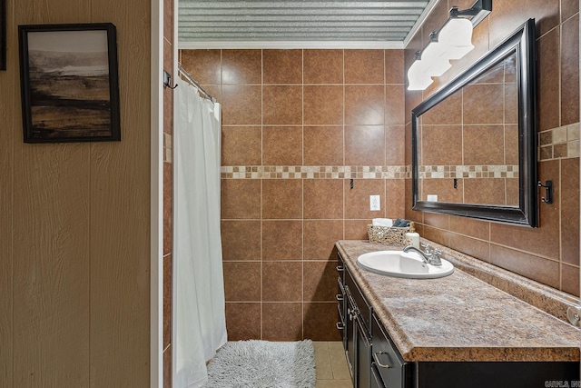 bathroom featuring ornamental molding, a shower with shower curtain, vanity, and tile walls