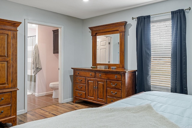 bedroom featuring baseboards and wood finished floors