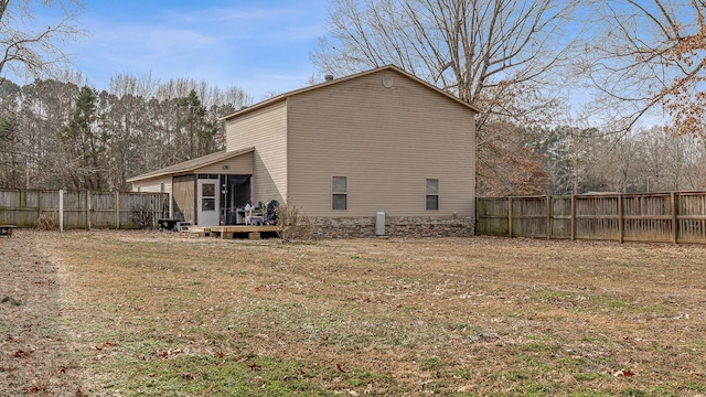 back of property with a sunroom and fence