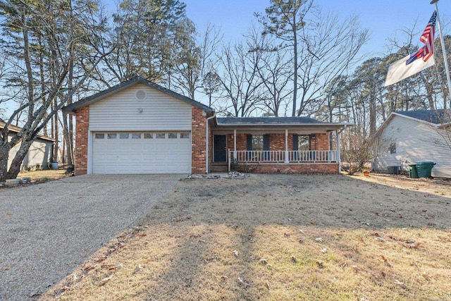 ranch-style house featuring covered porch, a front yard, and a garage