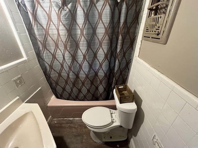 bathroom with toilet, tile walls, and shower / bath combo with shower curtain