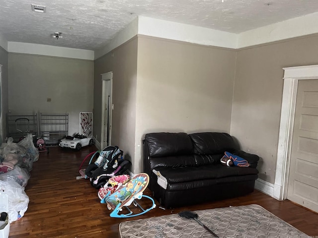 living room featuring a textured ceiling and dark wood-type flooring