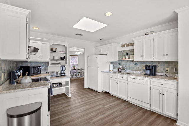 kitchen featuring white cabinetry, light stone countertops, white appliances, and a skylight