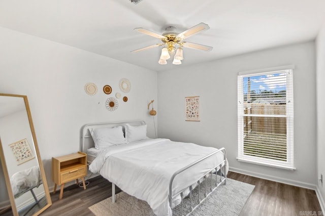 bedroom with ceiling fan, dark hardwood / wood-style flooring, and multiple windows