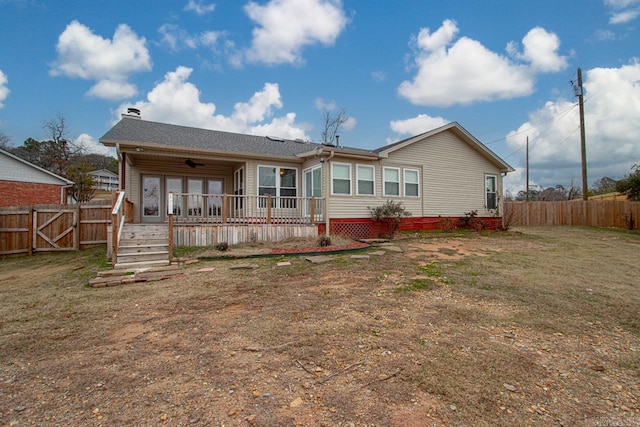 rear view of property with a yard, ceiling fan, and a wooden deck