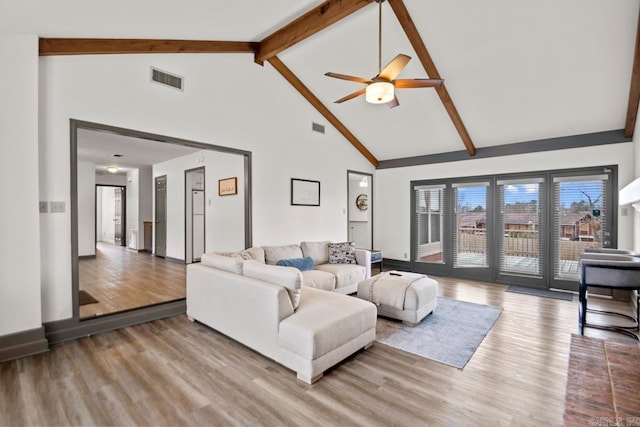 living room with hardwood / wood-style floors, high vaulted ceiling, ceiling fan, and beam ceiling