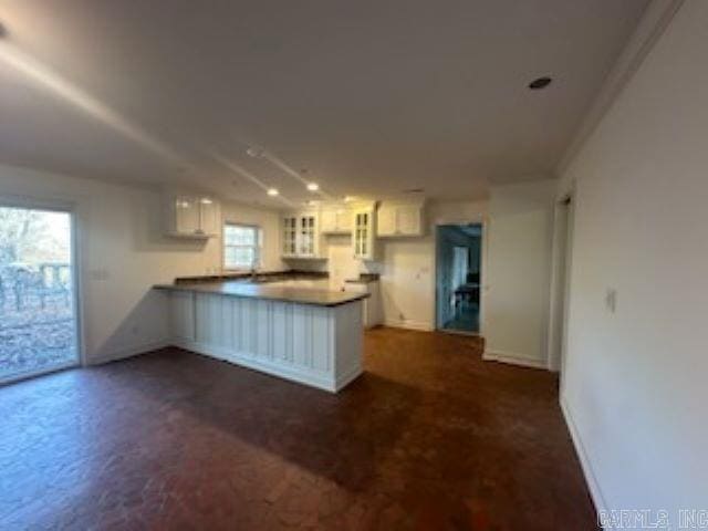 kitchen featuring kitchen peninsula and white cabinets