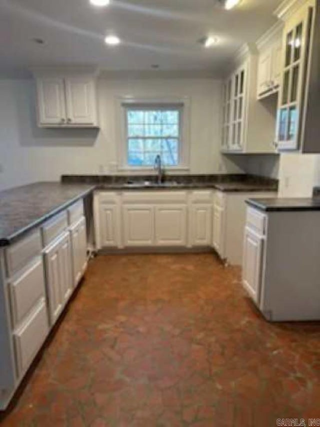 kitchen featuring white cabinetry and sink