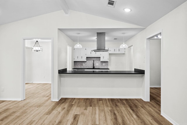 kitchen with pendant lighting, white cabinetry, island exhaust hood, and tasteful backsplash