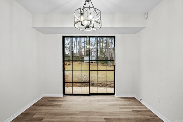 unfurnished dining area with light hardwood / wood-style flooring and a notable chandelier