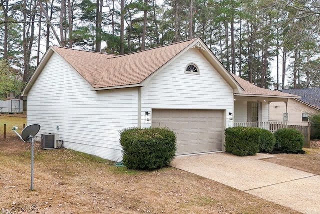 view of front of property with central air condition unit, a porch, and a garage