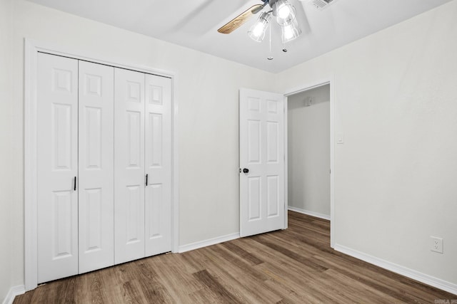 unfurnished bedroom with hardwood / wood-style flooring, ceiling fan, and a closet