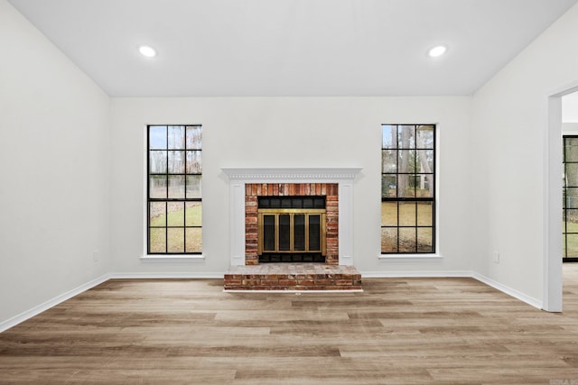 unfurnished living room featuring a fireplace and light hardwood / wood-style flooring