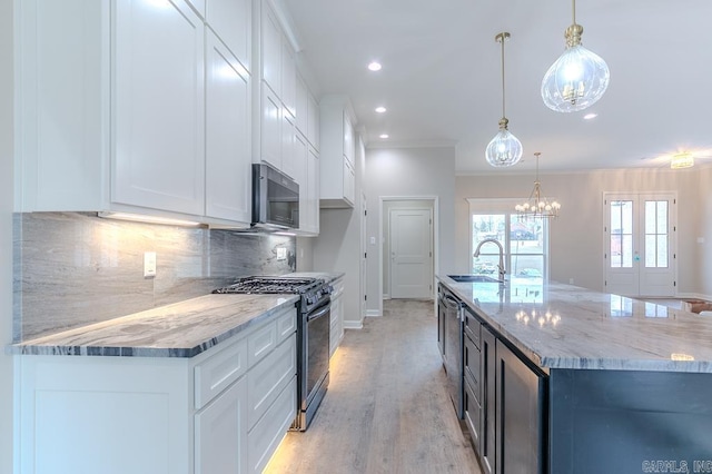 kitchen with white cabinetry, hanging light fixtures, and appliances with stainless steel finishes