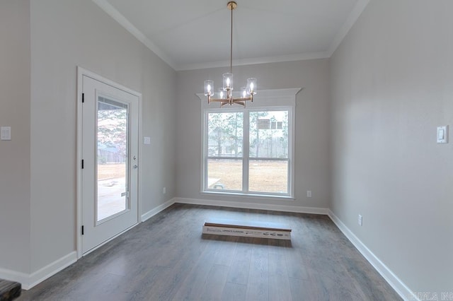 unfurnished dining area featuring dark hardwood / wood-style flooring, an inviting chandelier, and crown molding