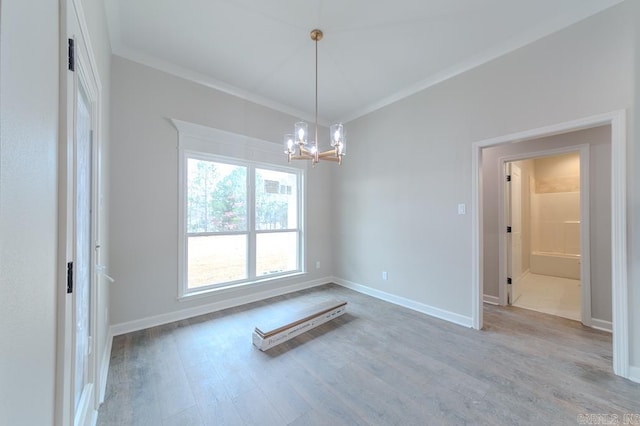 spare room with hardwood / wood-style floors, an inviting chandelier, and ornamental molding