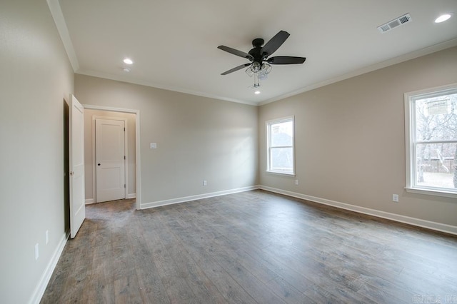 empty room featuring light wood-type flooring, a wealth of natural light, and ornamental molding