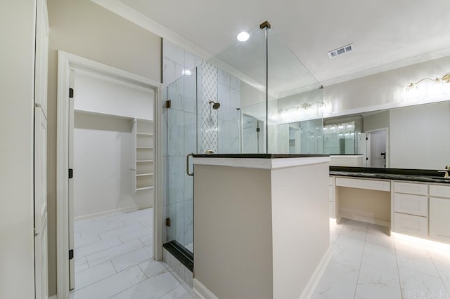 bathroom with vanity, a shower with shower door, and ornamental molding