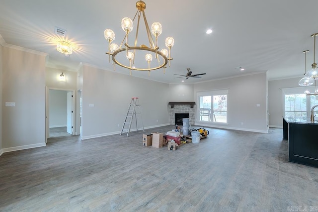 interior space featuring ceiling fan with notable chandelier, a stone fireplace, and crown molding