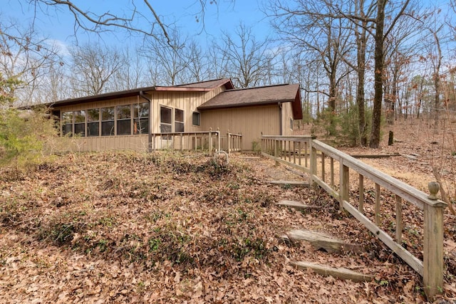 view of property exterior with a sunroom