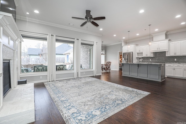 living room featuring ornamental molding, ceiling fan, and dark wood-type flooring