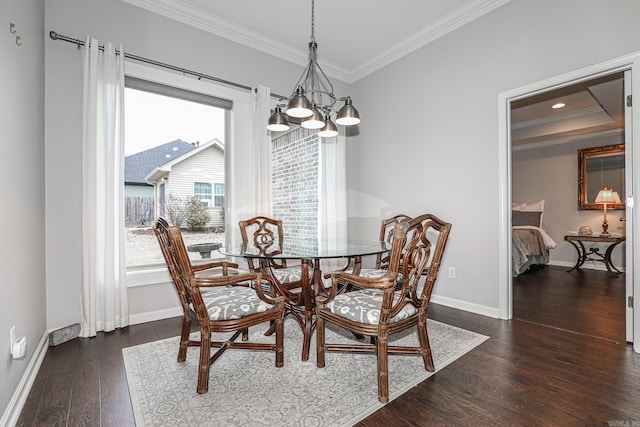 dining space featuring dark hardwood / wood-style flooring, crown molding, and a chandelier