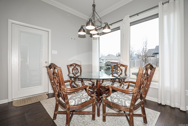 dining area with dark hardwood / wood-style floors, ornamental molding, and an inviting chandelier