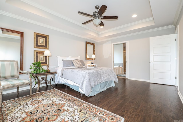 bedroom with dark hardwood / wood-style flooring, ensuite bathroom, a tray ceiling, ceiling fan, and crown molding