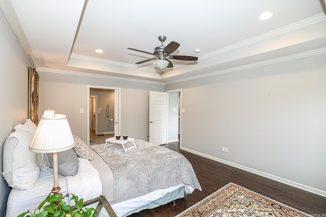 bedroom with dark hardwood / wood-style flooring, a raised ceiling, ceiling fan, and ornamental molding